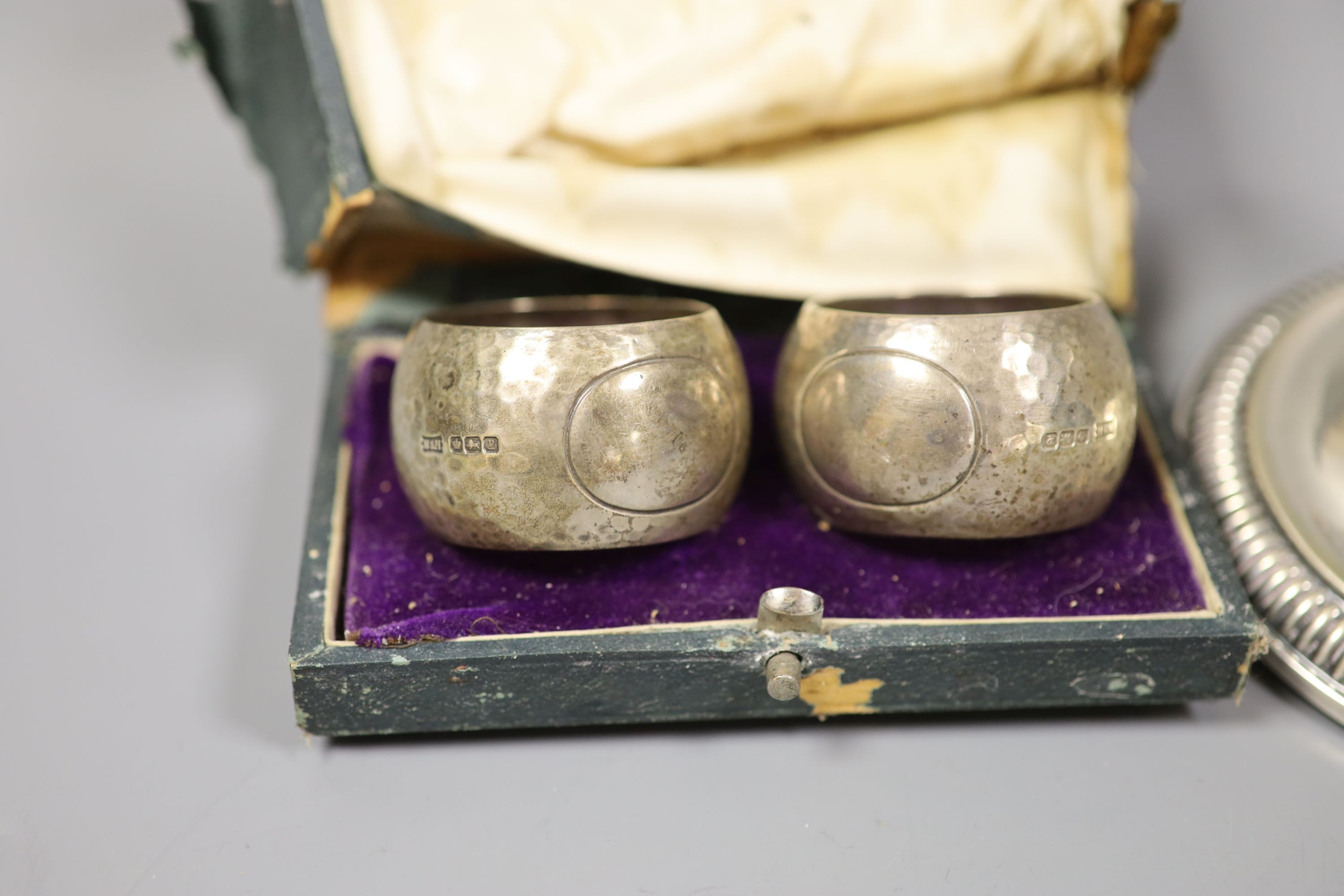 A German white metal dwarf candlestick and a cased pair of silver napkin rings by Walker & Hall.